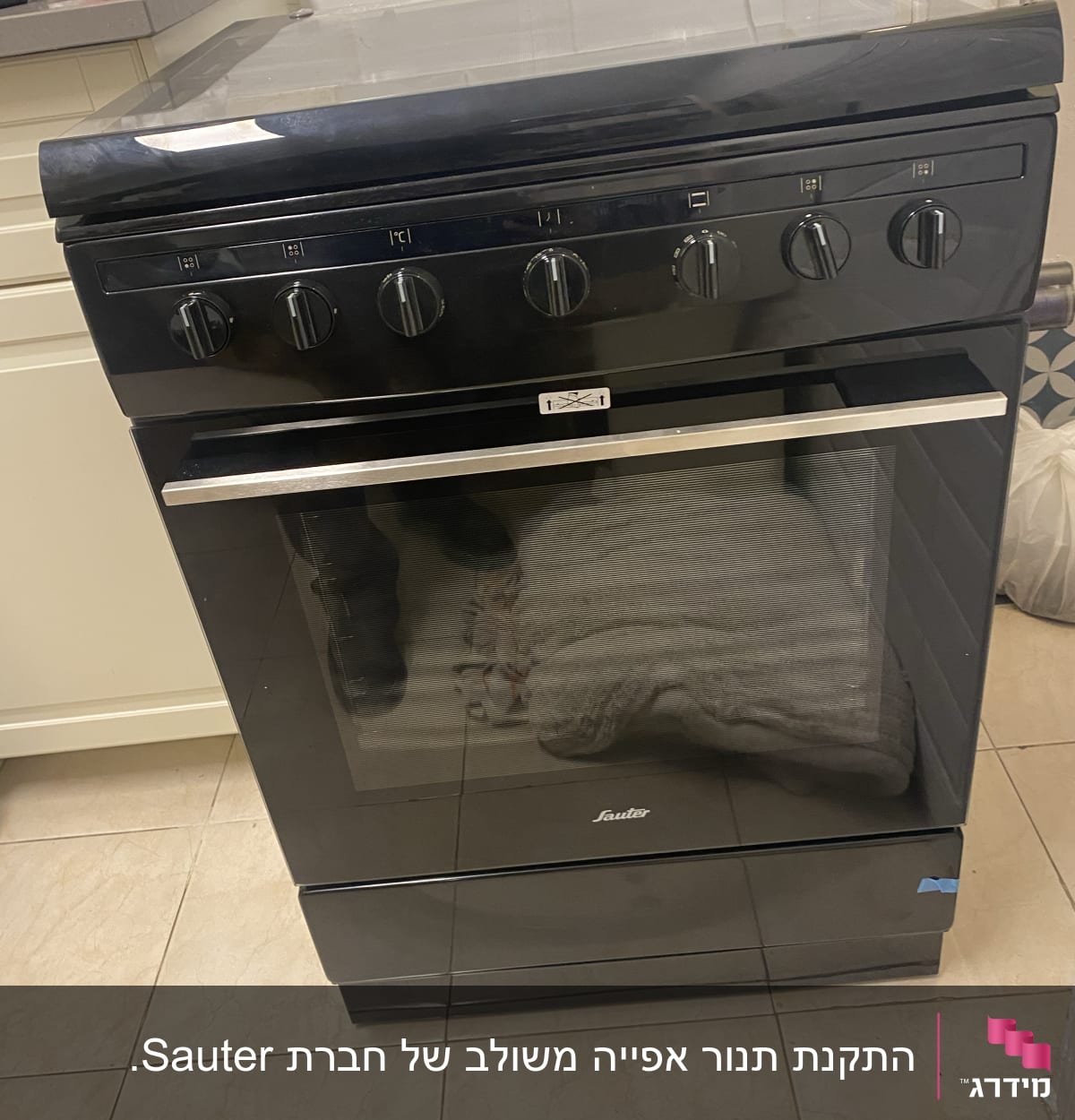 תנור גז שחור עם חמישה כפתורים עליונים
